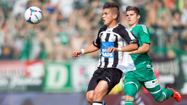 Zwei Fußballspieler während eines Spiels auf dem Rasen.