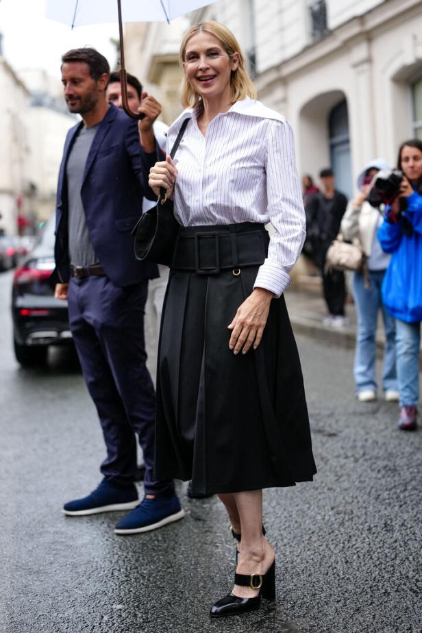 Eine Frau in einem gestreiften Hemd und einem schwarzen Rock mit breitem Gürtel in Paris.