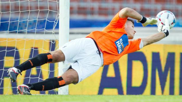 Ein Torwart hechtet, um einen Fußball zu fangen.