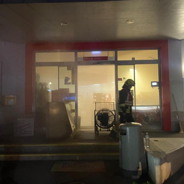 Ein Feuerwehrmann steht vor einer verrauchten Tankstelle in Maissau.