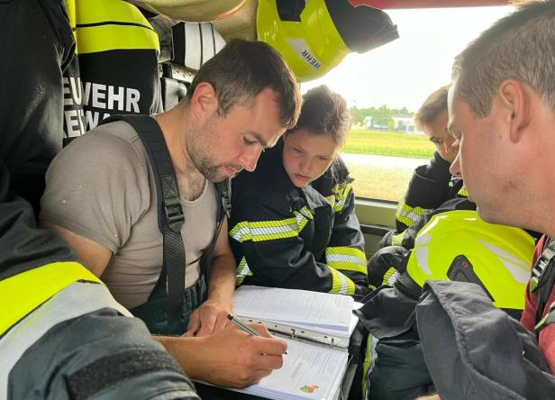 Feuerwehrleute der FF Breitenwaida füllen gemeinsam ein Formular aus.