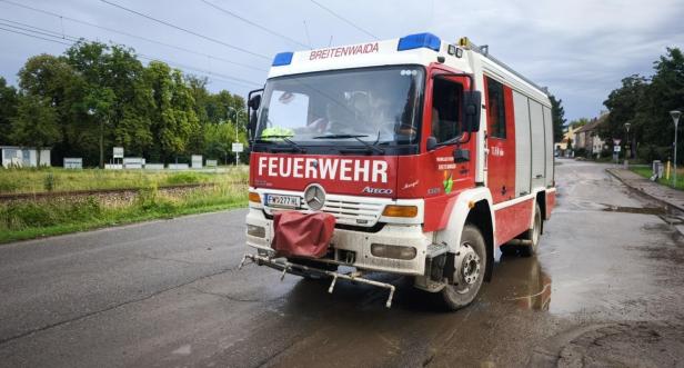 Ein Feuerwehrfahrzeug der Freiwilligen Feuerwehr Breitenwaida steht auf einer nassen Straße.