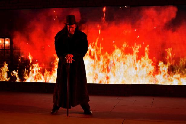 Ein Mann im Kostüm von Jekyll & Hyde steht vor einer Feuerwand auf der Felsenbühne.