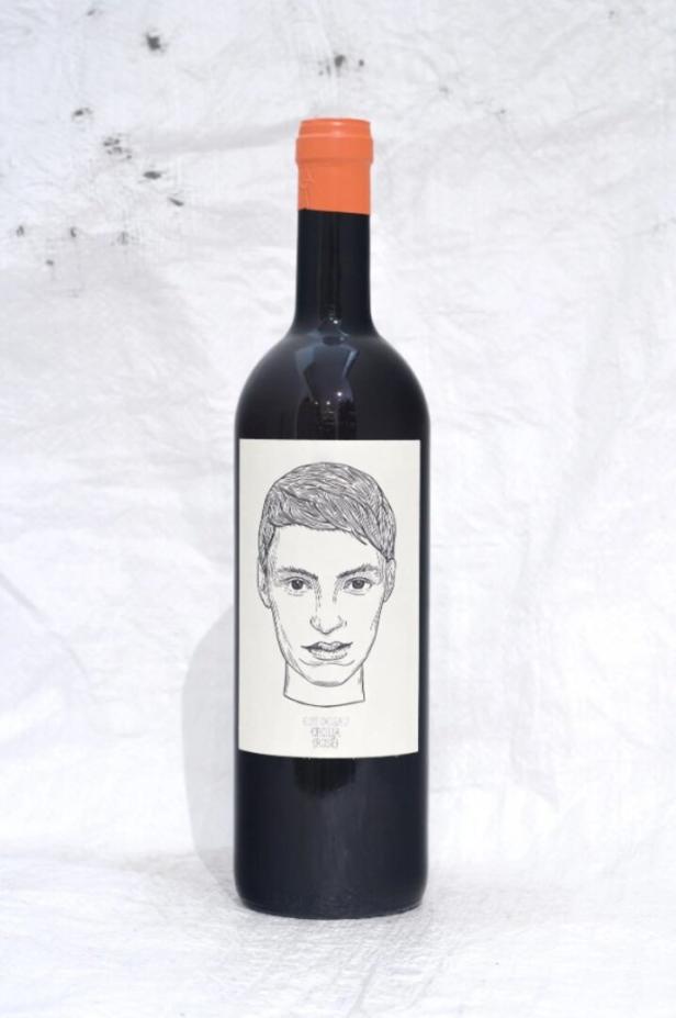 Eine Flasche Rotwein mit einem Porträt auf dem Etikett.