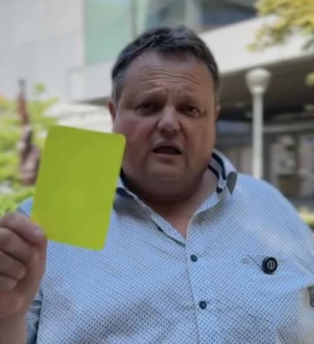 Der ehemalige Schiedsrichter Bernd Strobl mit einer gelben Karte im Vordergrund