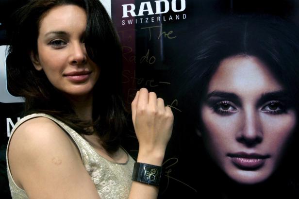 INDIA PEOPLE Eine Frau posiert mit einer Rado-Uhr vor einem Rado-Werbeplakat.