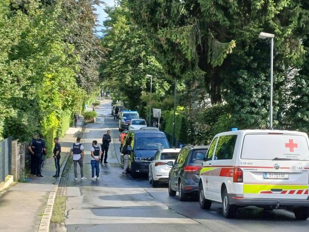 Polizisten und ein Rettungsauto in der Straße, wo sich die dramatischen Szenen abspielten.