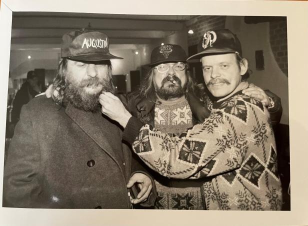 Drei Männer mit Bärten und Mützen posieren für ein Schwarzweißfoto.