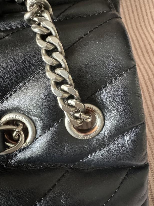 Detailaufnahme einer schwarzen Saint Laurent Tasche mit silberner Kette.