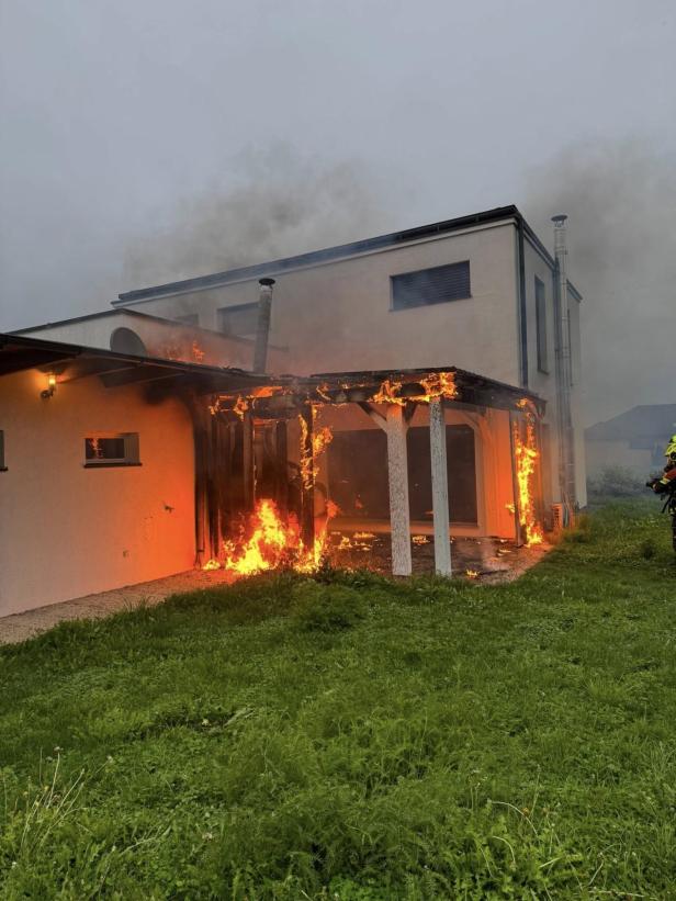 Ein Haus mit einer brennenden Veranda und starker Rauchentwicklung.