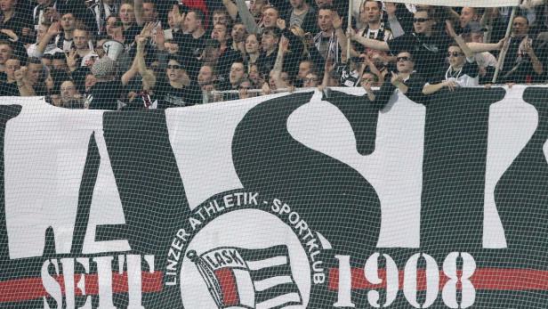 Fans des LASK Linz halten ein großes Banner im Stadion hoch.