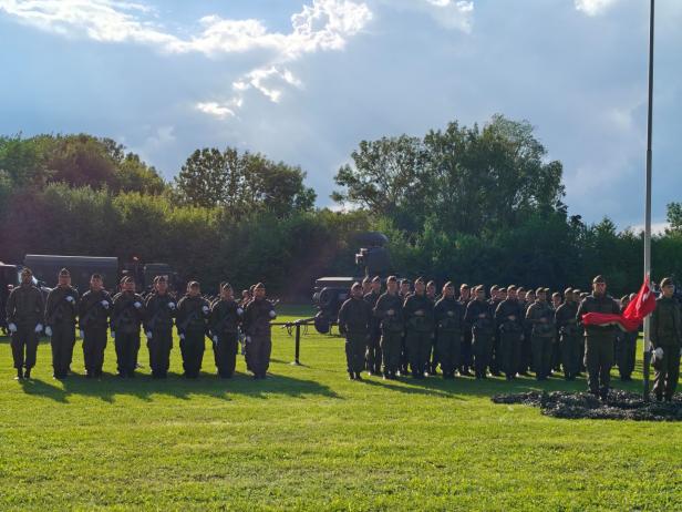 Soldaten stehen bei der Angelobung in Großharras auf einem Feld.