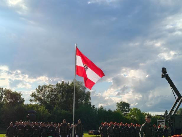 Soldaten stehen bei der Angelobung in Großharras vor der österreichischen Flagge.