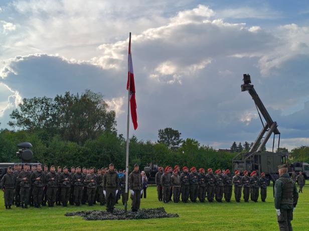 Soldaten stehen bei der Angelobung in Großharras auf einem Feld.