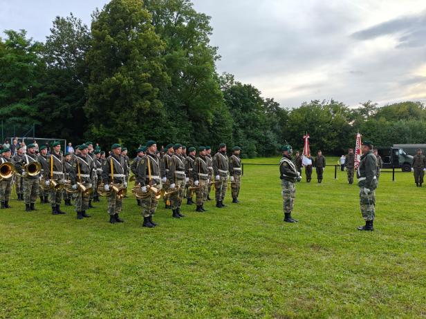 Eine Militärkapelle steht bei der Angelobung in Großharras auf einer Wiese.
