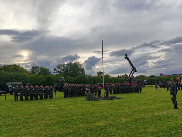 Soldaten stehen bei der Angelobung in Großharras auf einem Feld.