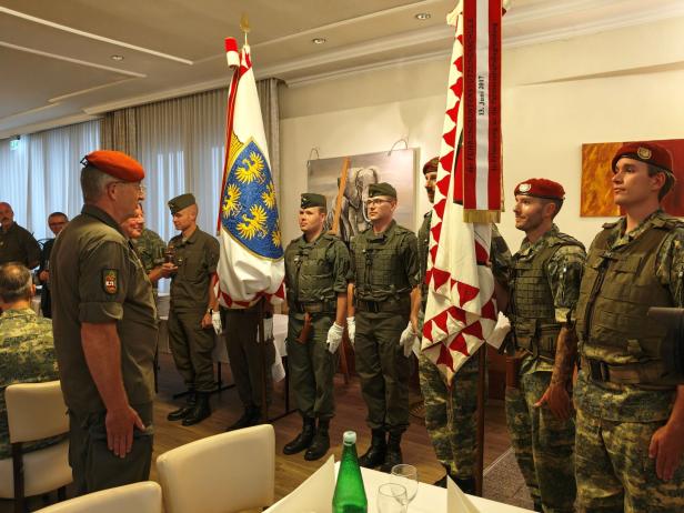 Soldaten stehen bei der Angelobung in Großharras mit Fahnen bereit.