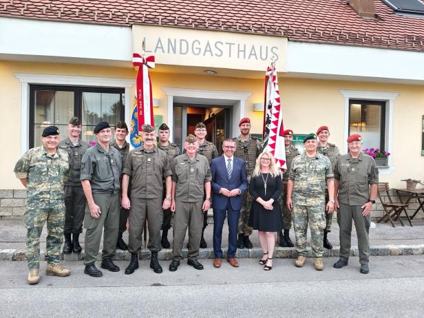 Eine Gruppe von Soldaten und Zivilpersonen vor dem Landgasthof Großharras.