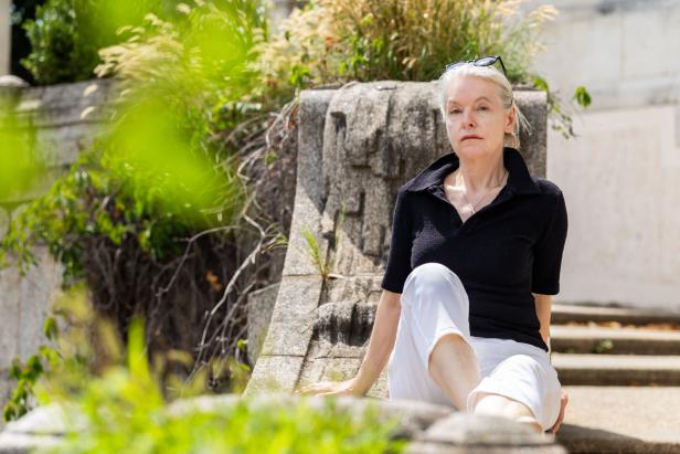 Marlene Streeruwitz sitzt auf einer steinernen Treppe.