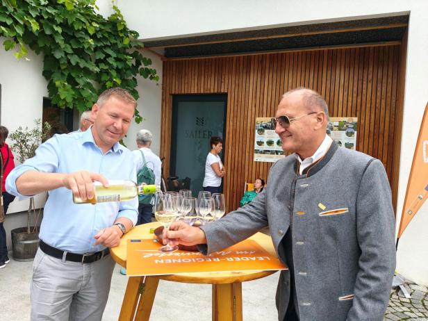 Ein Mann schenkt Wein bei der „Sommergenusstour Weinviertel“ ein.