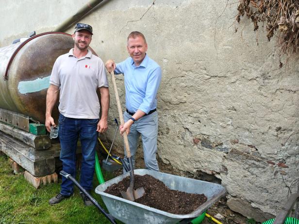 Zwei Männer stehen mit einer Schubkarre voller Erde im Weinviertel.