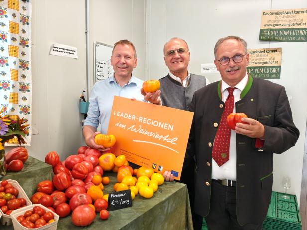 Drei Männer präsentieren Tomaten und ein Schild der „LEADER-Regionen im Weinviertel“.