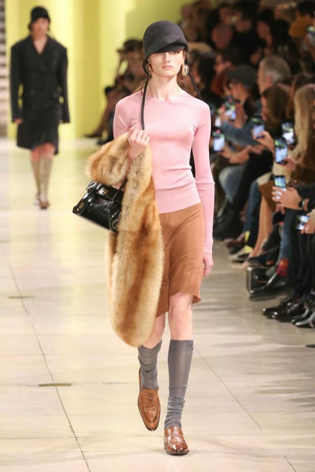 Ein Model präsentiert Mode von Miu Miu auf einem Laufsteg.