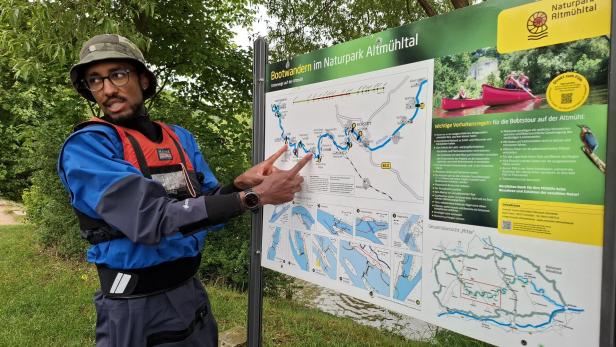 Ein Mann mit Schwimmweste deutet auf eine Karte für Bootstouren im Naturpark Altmühltal.
