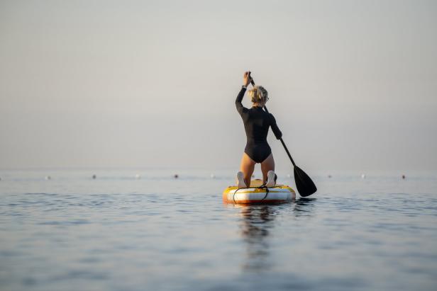Young woman paddle boarding in the sea at sunrise, Konyaalti Beach  Antalya, Turkiye