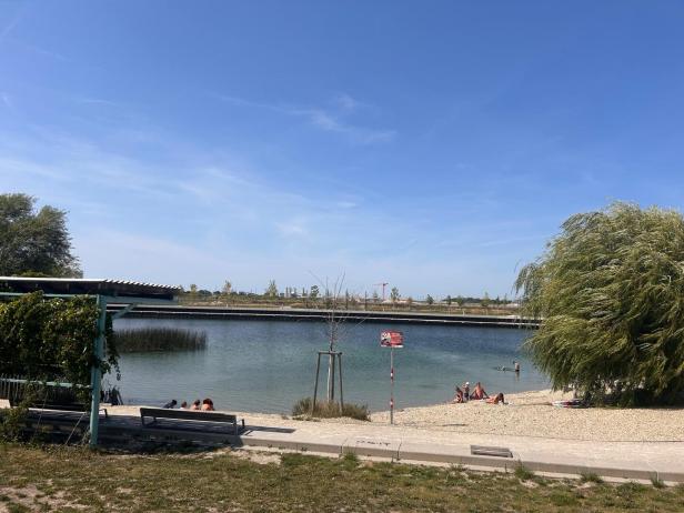 Badegäste entspannen am Strand der Seestadt Aspern in Wien.