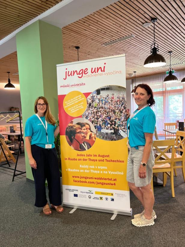Zwei Frauen stehen vor einem Banner der „Junge Uni Waldviertel-Vysočina“.