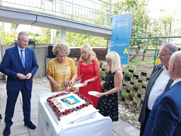 Eine Gruppe von Personen schneidet eine Torte zum 30-jährigen Jubiläum des PBZ Hollabrunn an.