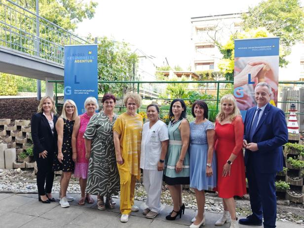 Eine Gruppe von Menschen posiert vor Bannern des PBZ Hollabrunn.