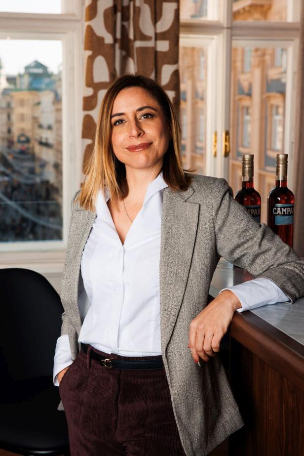 Camilla Cisterna posiert neben zwei Campari-Flaschen.
