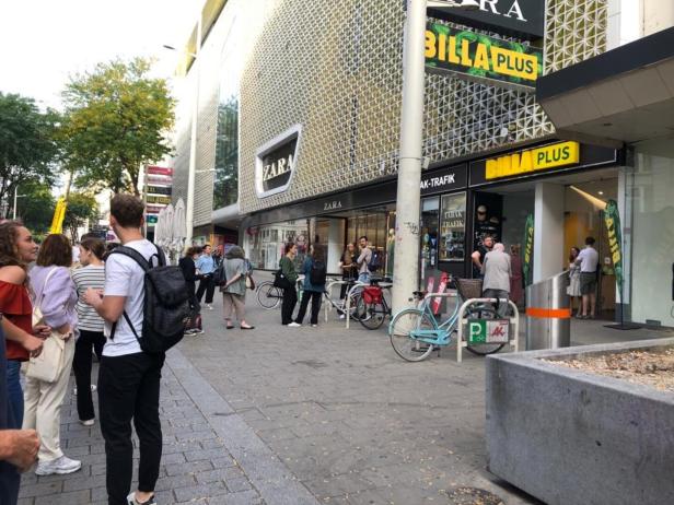 Menschen gehen an einem Zara- und Billa-Plus-Geschäft vorbei.