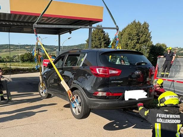 Ein schwarzer Kia Sportage wird von der Feuerwehr Göllersdorf mit Gurten angehoben.