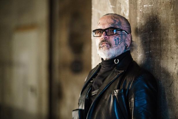 Ein Mann mit Tattoos im Gesicht bei der Esther Perbandt Runway Show, Mercedes-Benz Fashion Week Berlin FW 2022.
