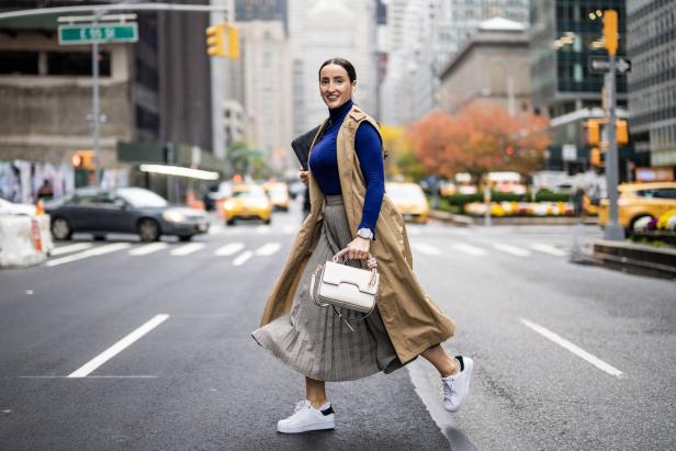 A woman seen running across the street in New York during a busy work day