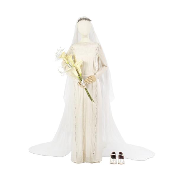 Eine Schaufensterpuppe trägt ein elfenbeinfarbenes Hochzeitskleid mit Schleier und hält einen Blumenstrauß.