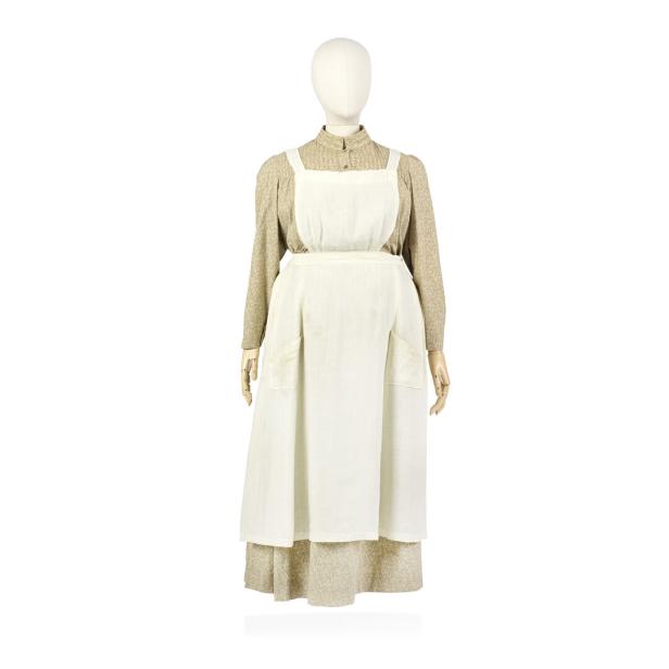 Eine Schaufensterpuppe trägt ein historisches Kleid mit Schürze.