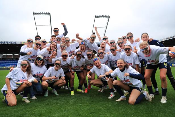 Ein Frauenteam in Trikots mit der Aufschrift „La Décima“ feiert auf einem Fußballfeld.