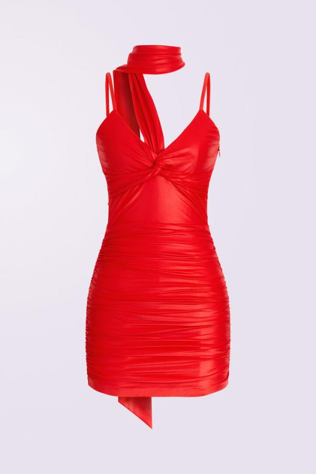 Ein rotes, gerafftes Minikleid mit Neckholder-Detail vor einem neutralen Hintergrund.