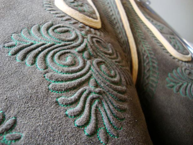 Detailaufnahme einer traditionellen Lederhose mit grüner Stickerei.