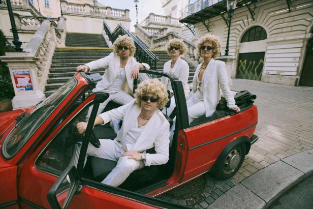 Dr. Bohl sitzt in einem roten Cabrio, mit ihm sitzen noch drei weitere Personen, alle als Dr. Bohl verkleidet, im Auto