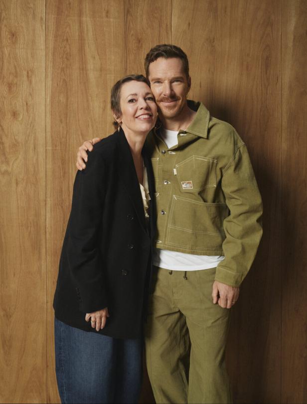 Benedict Cumberbatch und Olivia Colman posieren vor einer Holzwand.