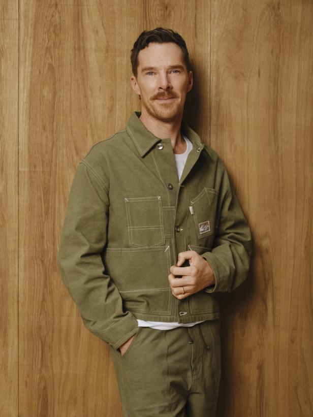Benedict Cumberbatch posiert vor einer Holzwand.