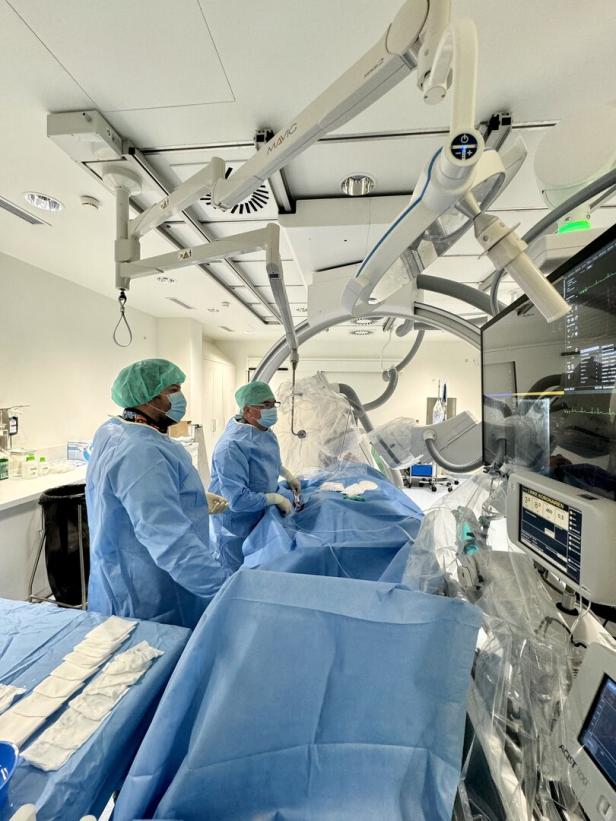 Zwei Ärzte in einem Operationsaal mit medizinischen Geräten und Monitoren