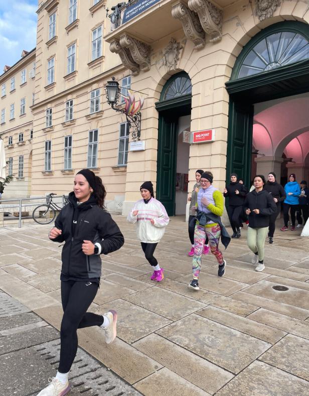 Eine Gruppe Frauen läuft vor einem Gebäude in Wien.