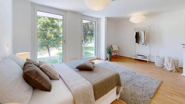 Ein Schlafzimmer mit einem Bett, einer Kommode und einem Fenster, das Tageslicht hereinlässt.