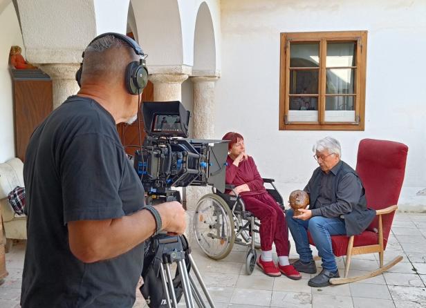 Monika und Manfred Pawlik werden gefilmt, während Manfred eine Skulptur hält.